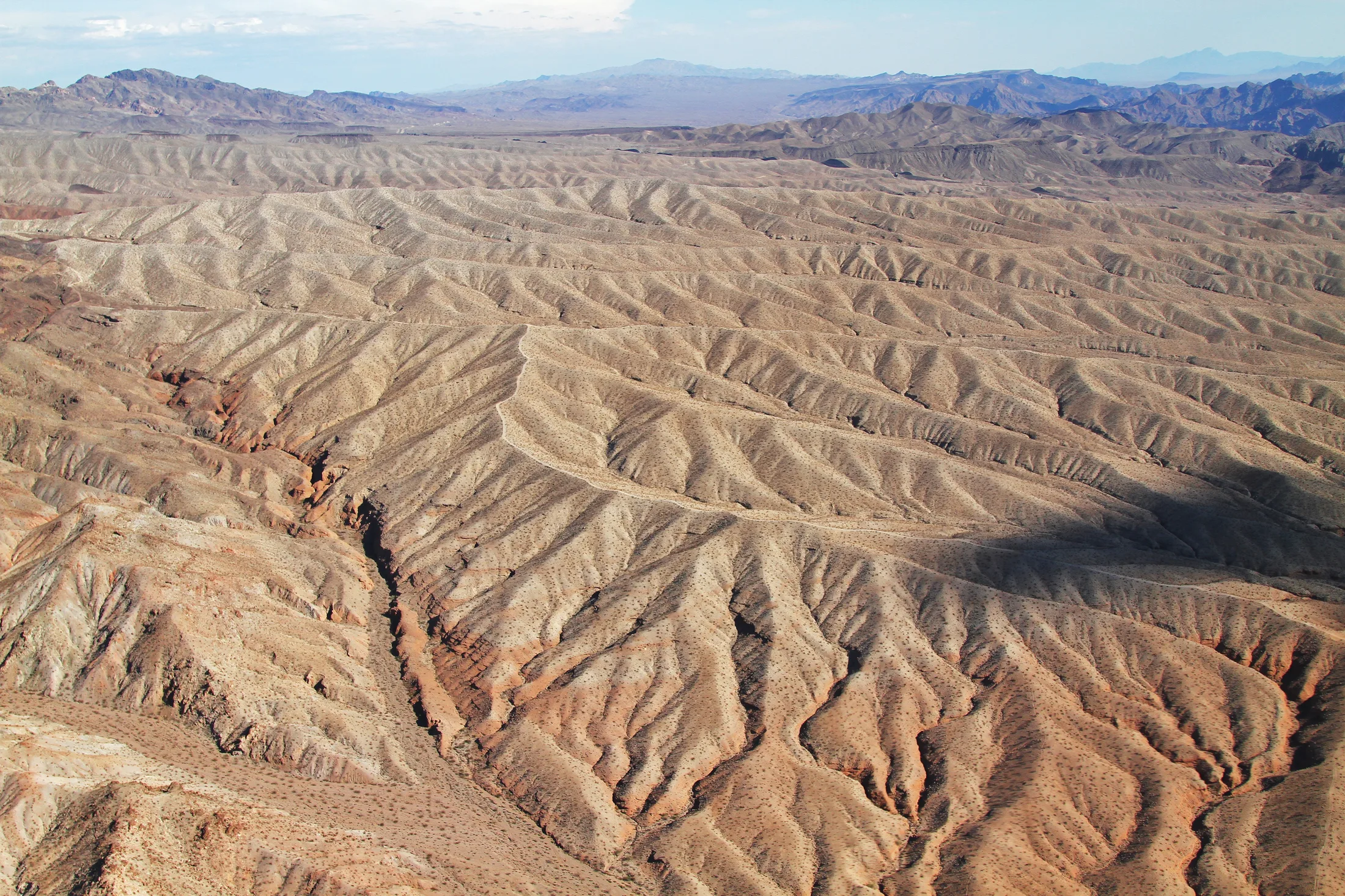 Aerial desert terrain with ridges and dry channels